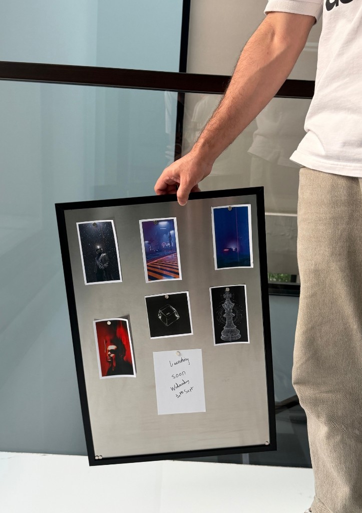 Person holding a Metalli Magnetic Board with photos and a launch note